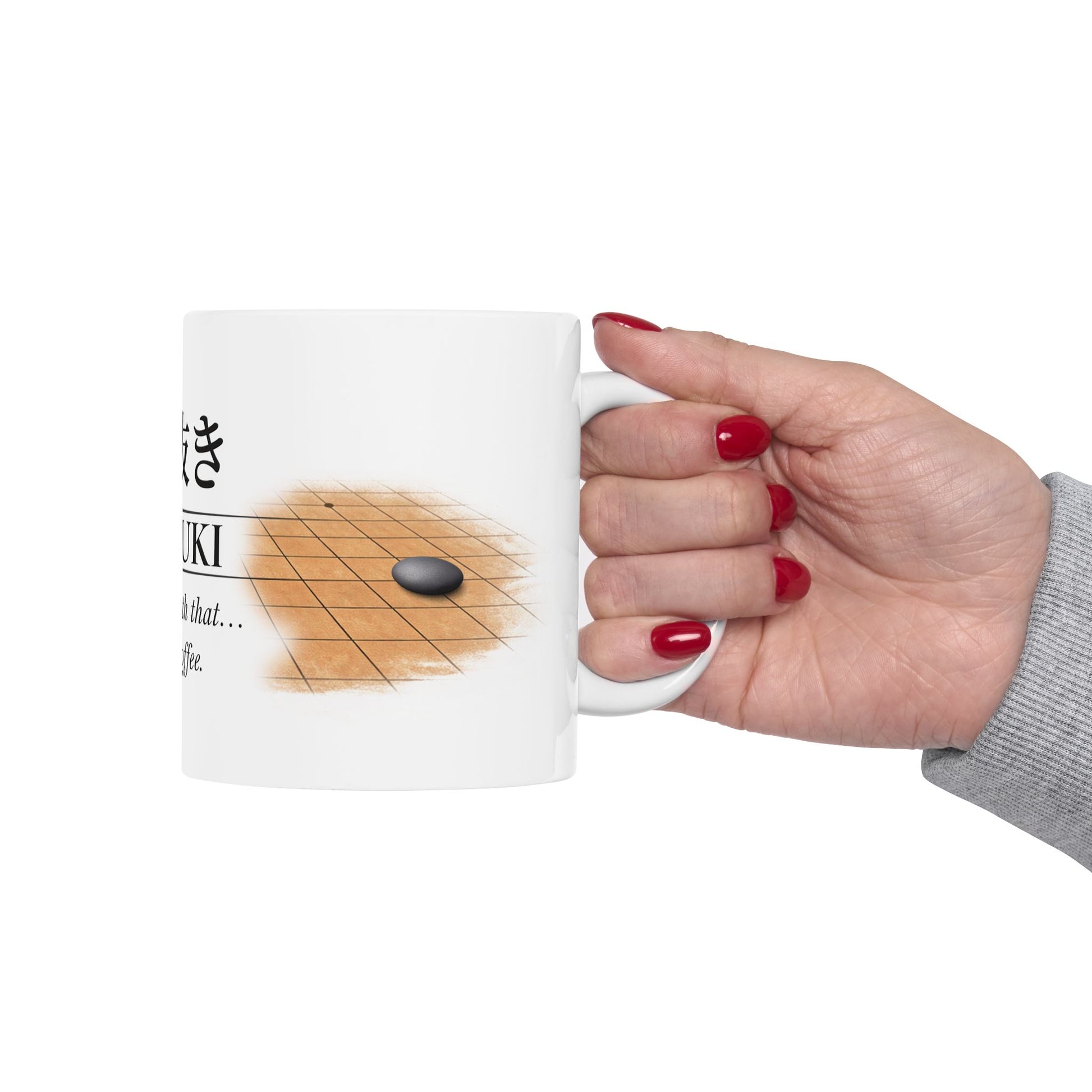 Hand holding a mug with a game of Go design on a white background