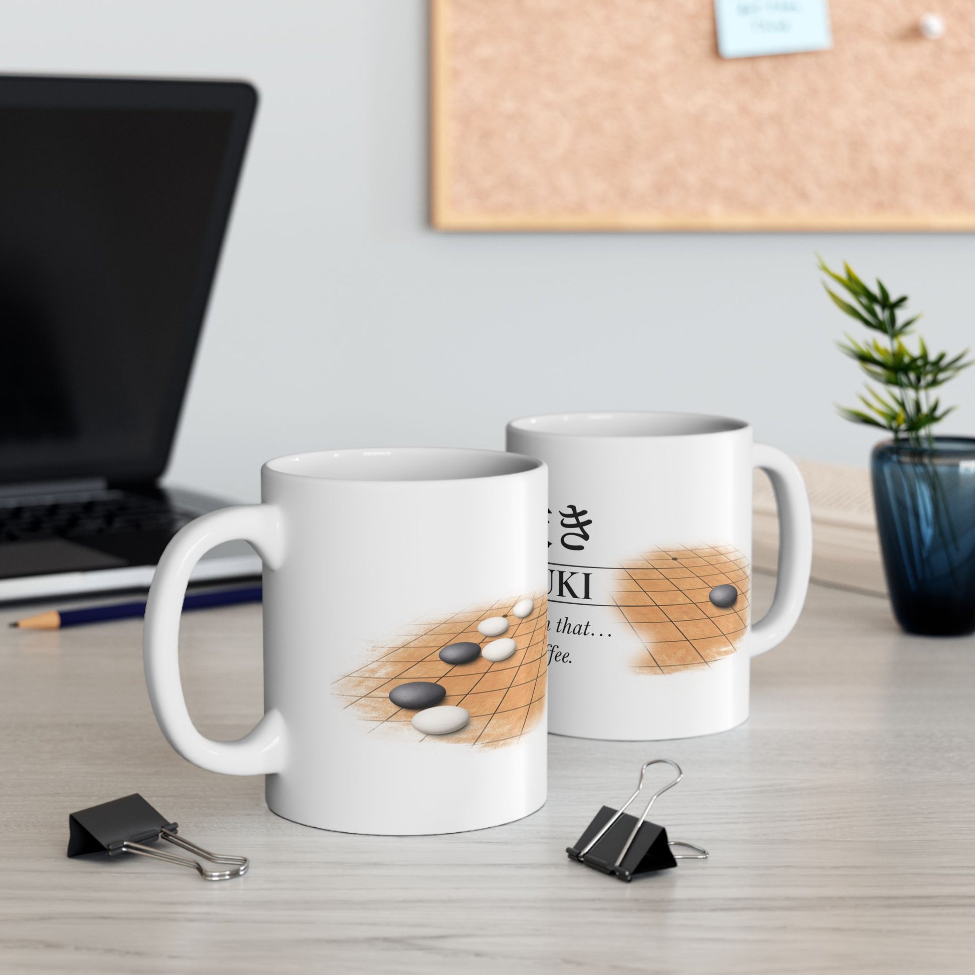 Two mugs with go board designs on a desk with office supplies.